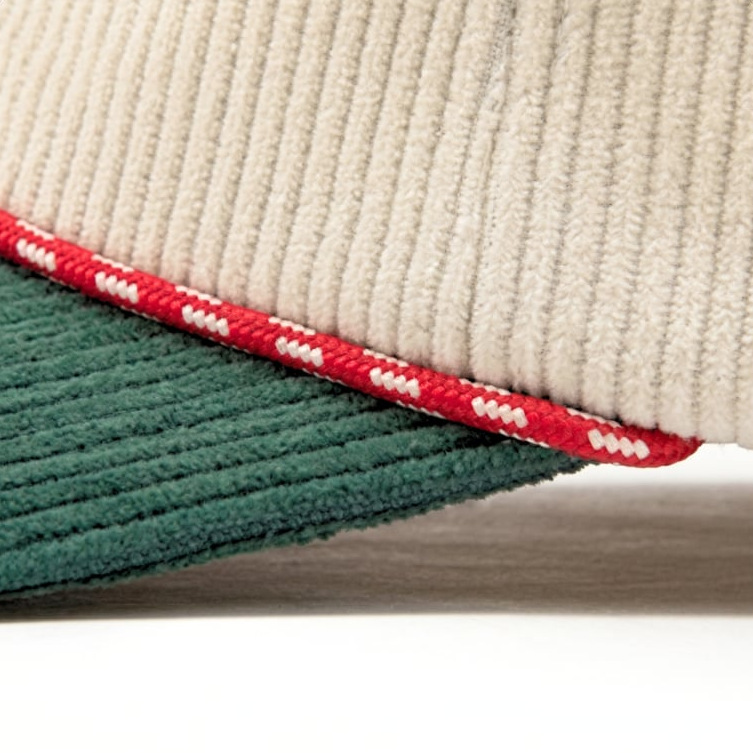 Red and white rope along a green corduroy brim