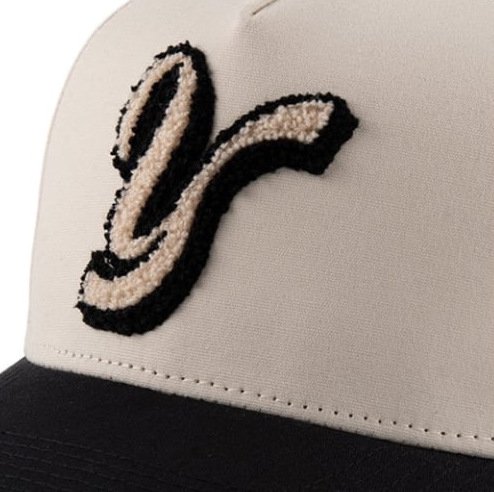 Chenille letter on a cream cap with a black brim