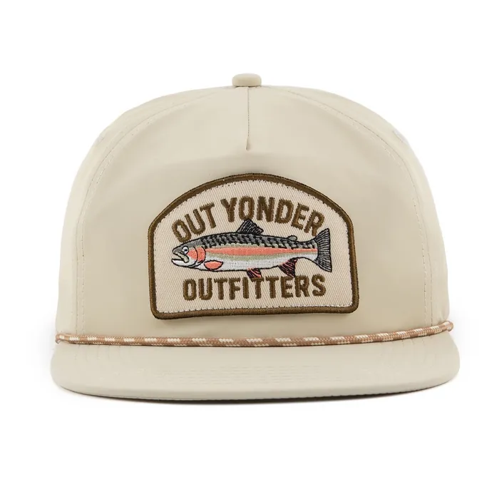 Unstructured five-panel hat, cream with flat brim, woven arch patch with a trout, twisted rope along the brim, small woven label on the strap