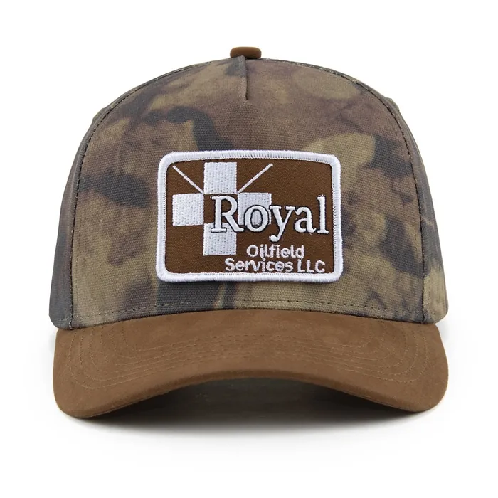 Five-panel camouflage hat with a brown suede brim, rectangular woven patch